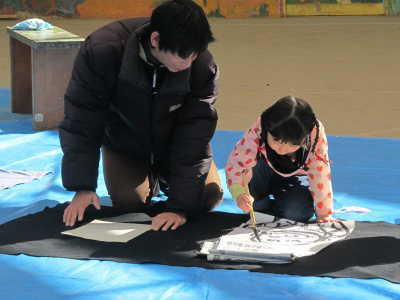 （写真）親子で書き初めをする姿