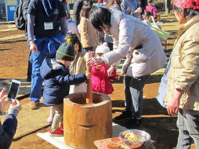 （写真）小さい杵で親子でもちつき体験をする様子