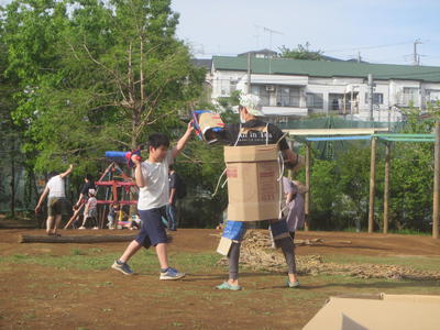 スタッフと子どもがダンボールで戦っている風景