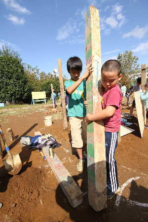 (写真)二人で協力して柱を建てる男の子たち
