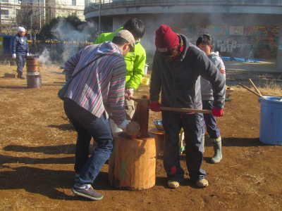 (写真)大人が三人がかりでもちをこねている様子。