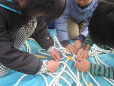 （写真）ロープを編む子どもたち