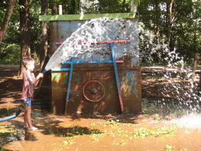 (写真)ホースから水を出す子ども。